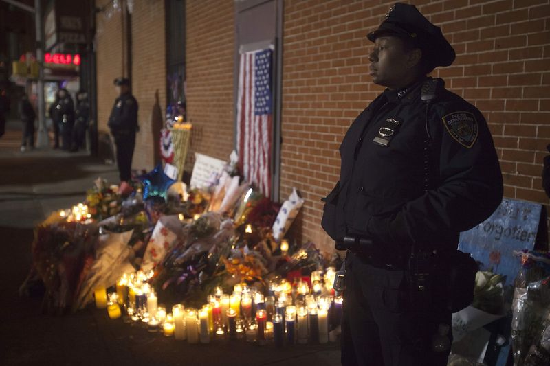 © Reuters. Policiais montem guarda no local em que foi montada uma vigília improvisada, onde dois policiais foram mortos a tiros, no Brooklin, em Nova York 