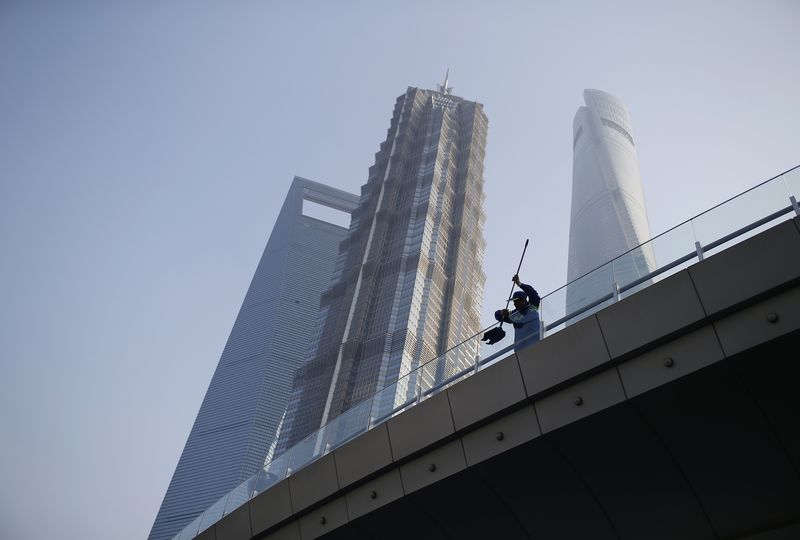 © Reuters. A worker cleans a glass wall in the financial district of Pudong in Shanghai