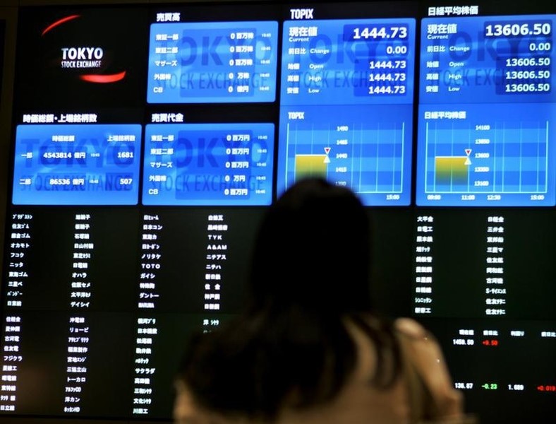 © Reuters. Woman looks up at TSE board with no flashing stock prices due to system glitch in Tokyo