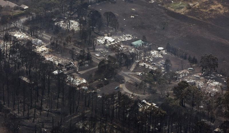 © Reuters. The remains of houses destroyed by bushfires are seen in the town of Wandong