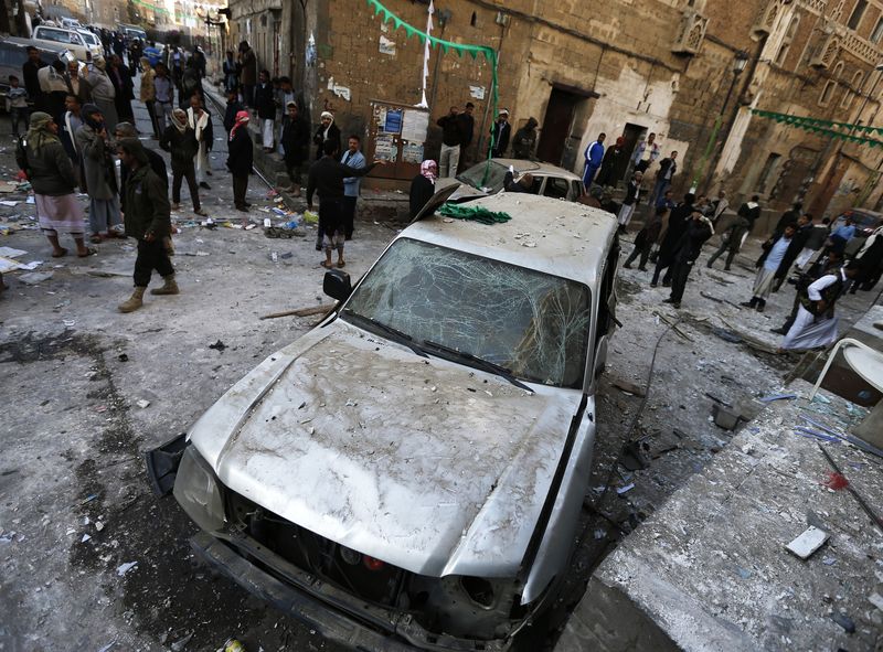 © Reuters. People gather at the site of a bomb explosion in Sanaa