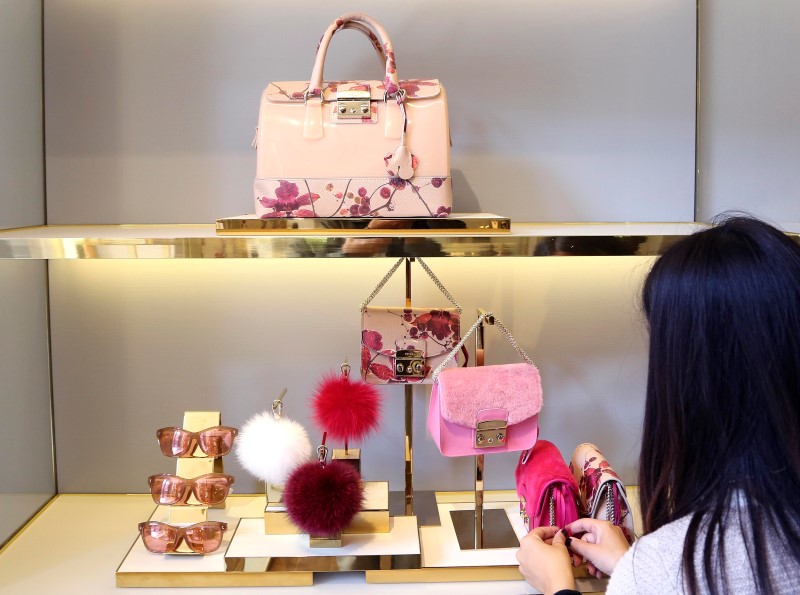 © Reuters. A shop assistant arranges bags in the window at the Furla flagship downtown Milan