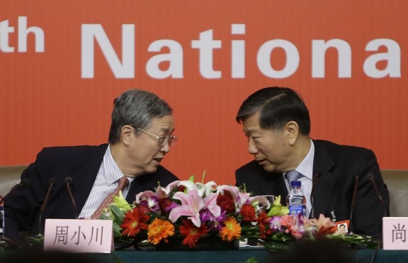 © Reuters. China's Central Bank Governor Zhou talks to Chairman of China Banking Regulatory Commission Shang during news conference in Beijing