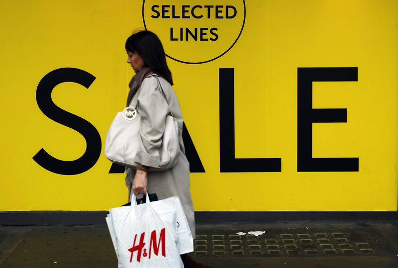 © Reuters. A shopper passes a sale sign in a shop window, in the run-up to Christmas, in central London