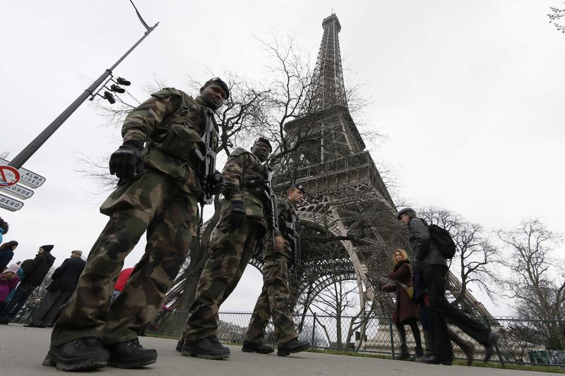 © Reuters. French soldiers patrol near the Eiffel Tower in Paris as part of the "Vigipirate" security plan