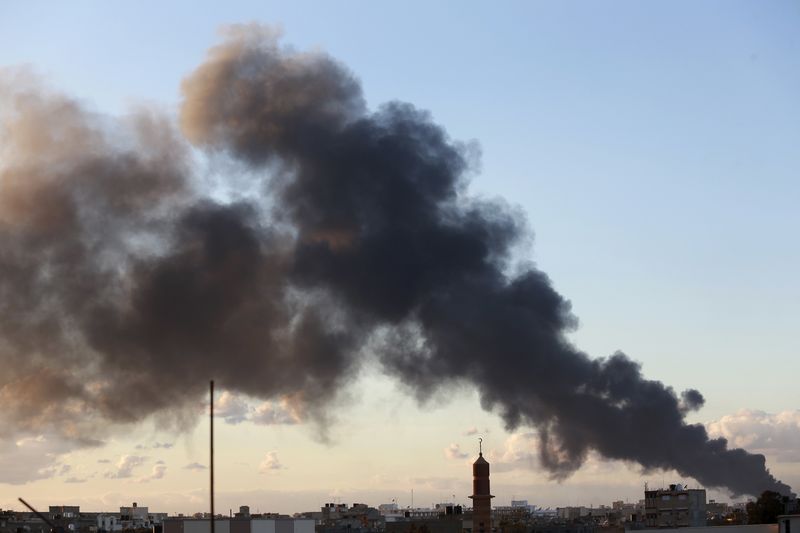 © Reuters. Black smoke billows in the sky above areas where clashes are taking place between pro-government forces and the Shura Council of Libyan Revolutionaries in Benghazi