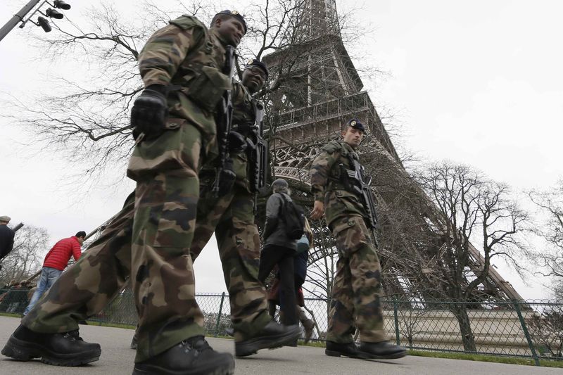 © Reuters. Soldados franceses fazem segurança da Torre Eiffel, em Paris