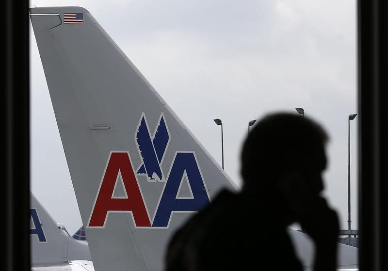 © Reuters. A passenger walks by an American Airlines airplane at a gate at the O'Hare Airport in Chicago, Illinois