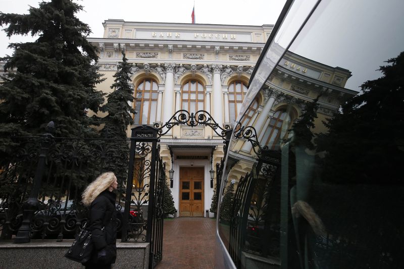 © Reuters. A woman walks past the headquarters of the Central Bank in Moscow