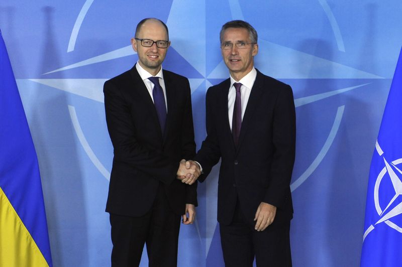 © Reuters. O Secretário-Geral da Otan, General Stoltenberg (à direita), aperta as mãos do premiê ucraniano Yatseniuk