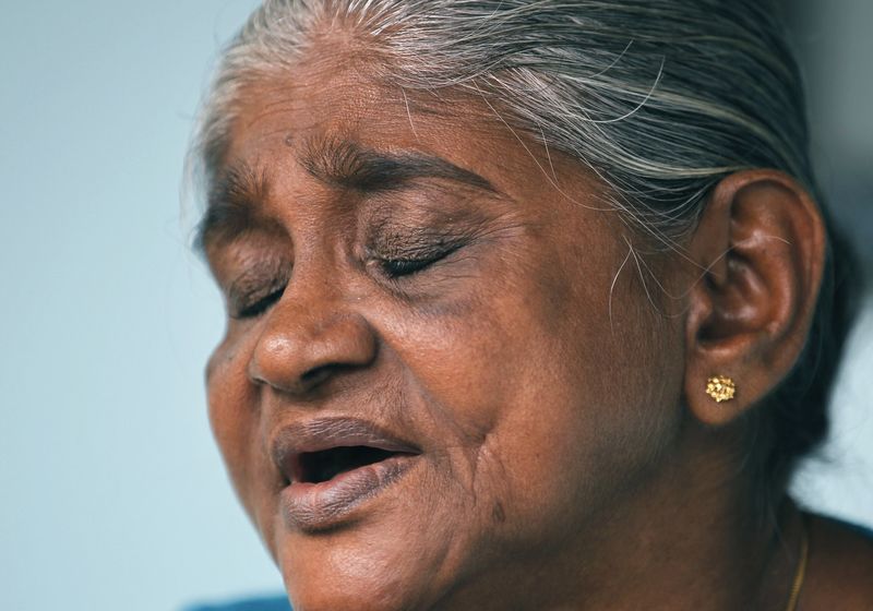 © Reuters. Karunawathi reacts as she talks with Reuters at her home inside the Tsunami village in Seenigama