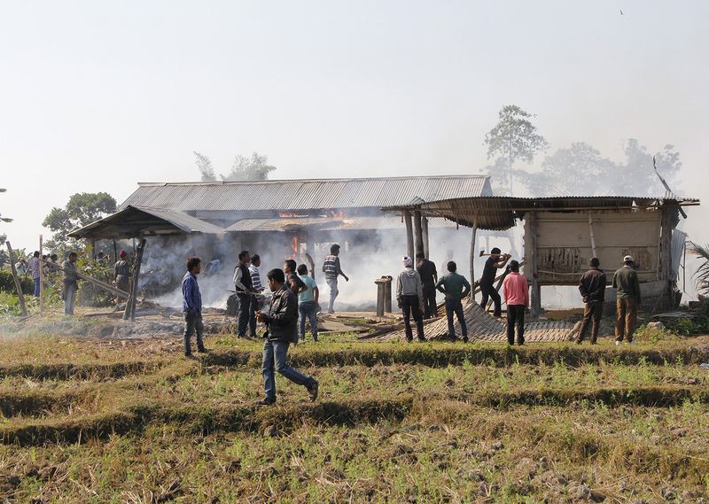 © Reuters. Tribal plantation workers burn houses belonging to indigenous Bodo tribesmen after ethnic clashes in Balijuri village