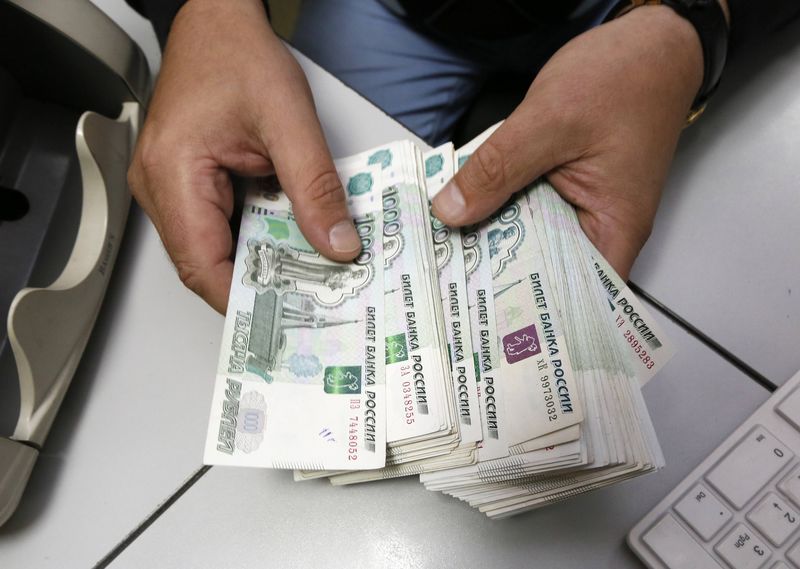 © Reuters. An employee counts Russian ruble banknotes at a private company's office in Krasnoyarsk