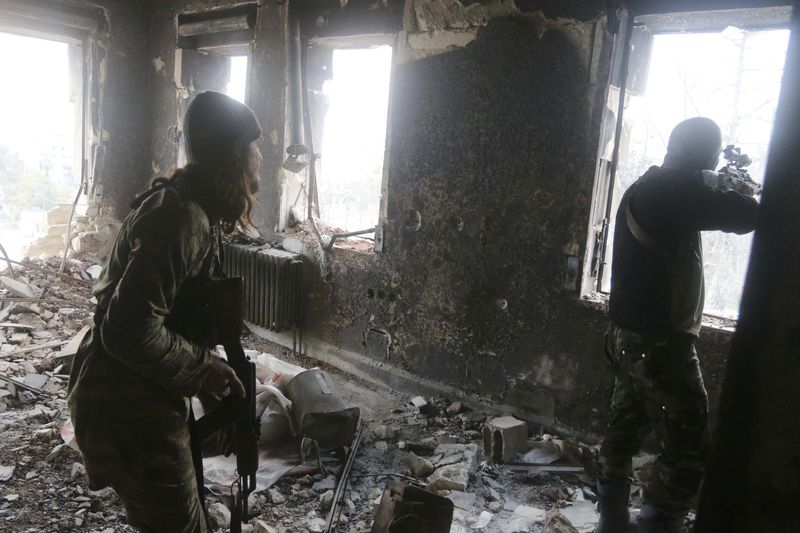 © Reuters. Rebel fighters take positions inside a damaged building during clashes with forces loyal to Syria's President Assad who are stationed in Aleppo's historic citadel