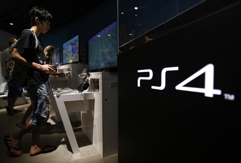 © Reuters. File picture of a man plays a video game on Sony Corp's Play Station 4 console at its showroom in Tokyo