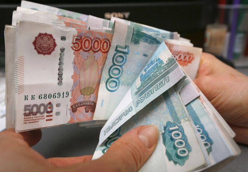 © Reuters. An employee counts Russian rouble banknotes at a small private shop in Krasnoyarsk