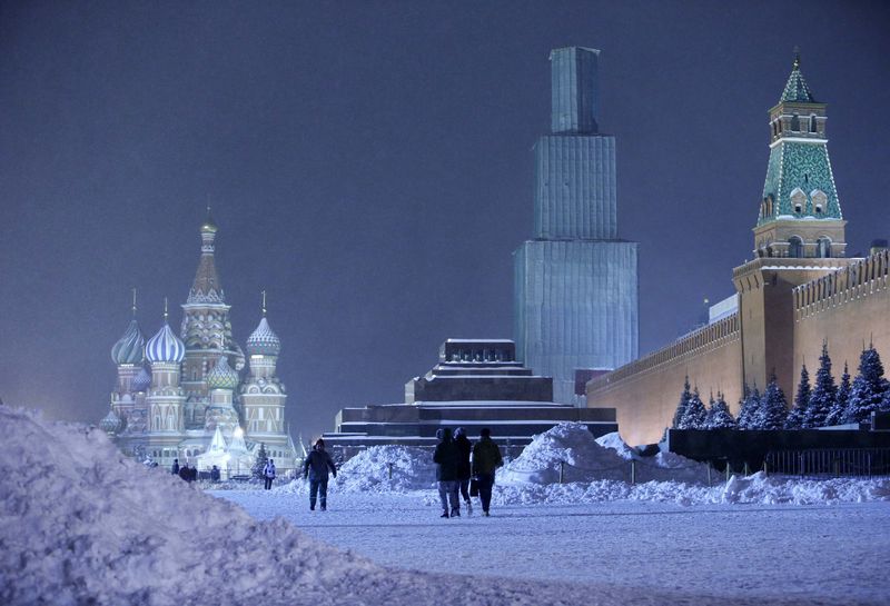 © Reuters. Pessoas andam na Praça Vermelha coberta por neve, em Moscou