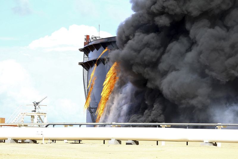 © Reuters. Fumaça negra sobe de um tanque de armazenamento de petróleo no porto de Es Sider