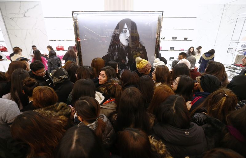 © Reuters. Bargain hunters crowd around the Saint Laurent handbag stall at Selfridges department store on the first day of their sales, in central London