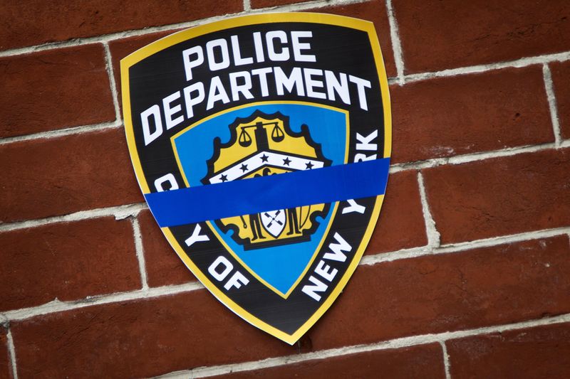 © Reuters. An NYPD logo is pictured on a wall above a makeshift memorial at the site where two police officers were shot in the head in the Brooklyn borough of New York
