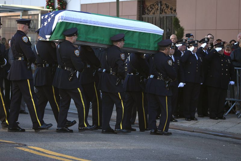 © Reuters. مشيعو شرطي قتيل يتجمعون لوداعه في كنيسة بنيويورك