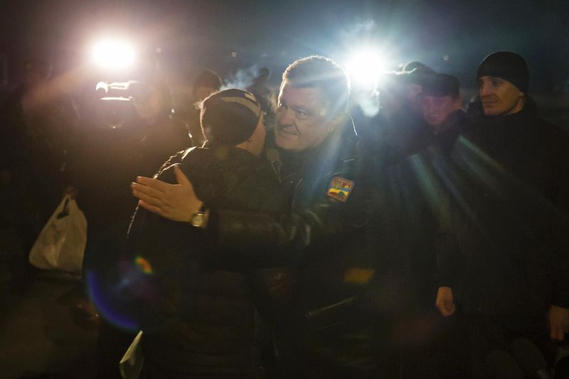 © Reuters. Ukraine's President Petro Poroshenko greets a Ukrainian prisoner-of-war returning home after being exchanged for pro-Russian separatist prisoners, in Kiev