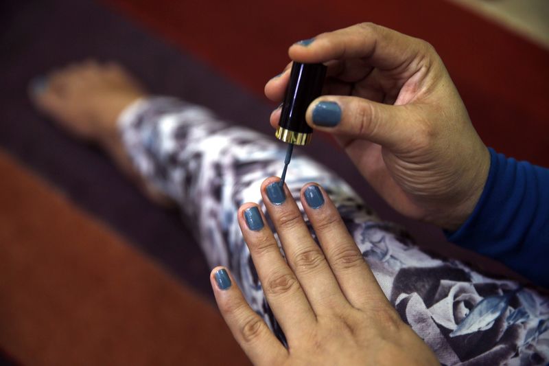 © Reuters. The fingernails of a transgender person are seen as she applies nail polish at her office in Banda Aceh