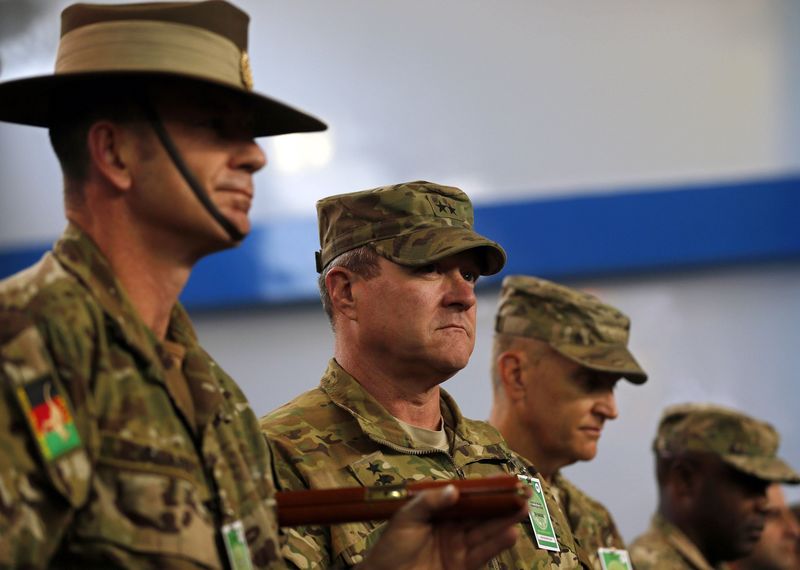 © Reuters. NATO-led International Security Assistance Force (ISAF) officers stand at attention during the change of mission ceremony in Kabul