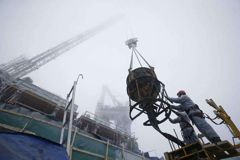 © Reuters. Builders work on the top 95th floor of the Federation Tower in Moscow