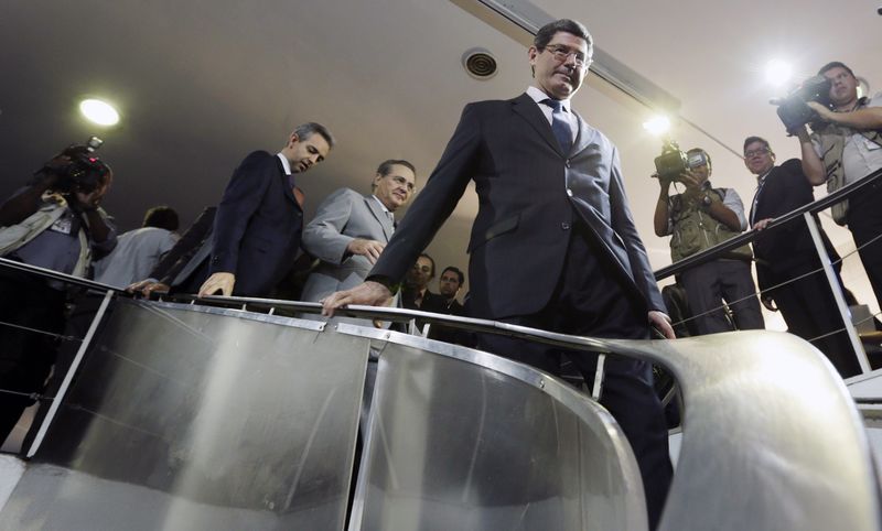 © Reuters. Brazil's incoming finance minister Levy walks next to Brazil's Senate President Calheiros after a meeting in Brasilia