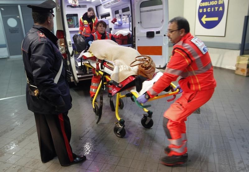 © Reuters. Pessoas resgatada da embarcação é transportada por médicos na chegada ao hospital 