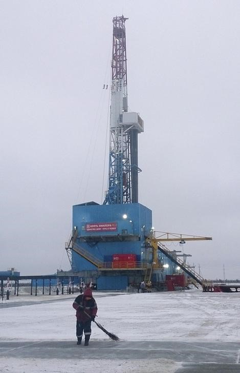 © Reuters. Funcionário varre terreno perto de poço de petróleo na Sibéria