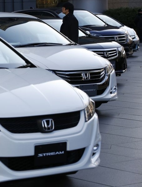 © Reuters. A man looks at Honda Motor Co cars displayed outside the company's showroom in Tokyo