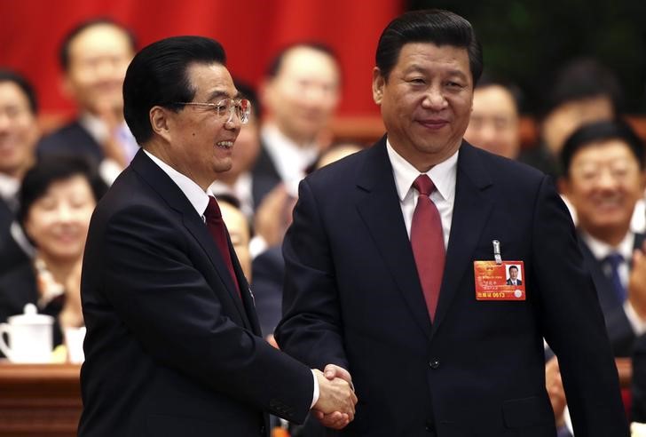 © Reuters. Hu Jintao shakes hands with China's newly elected President and chairman of the Central Military Commission Xi Jinping during the fourth plenary meeting of the first session of the 12th National People's Congress (NPC) in Beijing