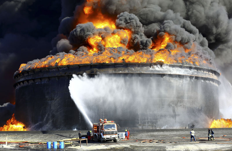 © Reuters. Firefighters work to put out the fire of a storage oil tank at the port of Es Sider in Ras Lanuf