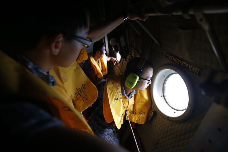 © Reuters. Agentes da Força Aérea de Cingapura tentam achar avião da Air Asia