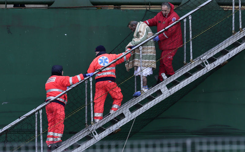 © Reuters. Passageiro ferido recebe ajuda para desembarcar em Bari