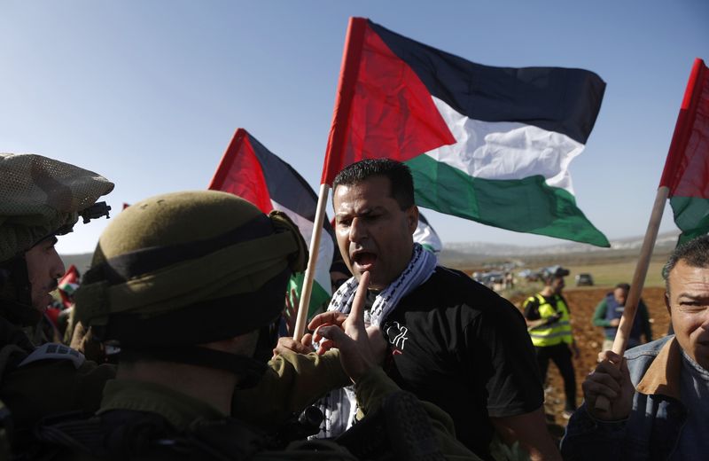 © Reuters. Manifestante palestino discute com soldados israelenses