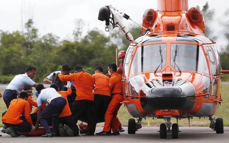 © Reuters. Equipes de resgate e busca da Indonésia descarregam corpo de duas vítimas do acidente aéreo da AirAsia em Pangkalan Bun. 31/12/2014 REUTERS/Darren Whiteside