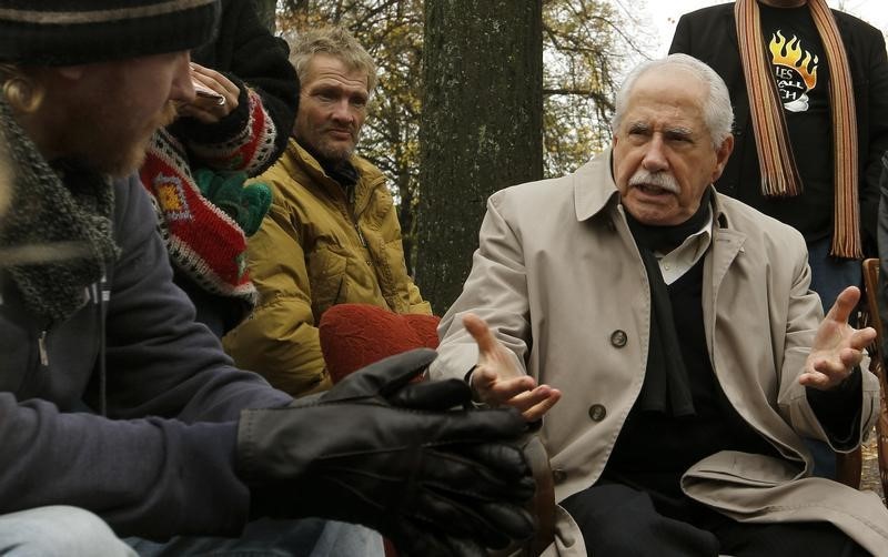 © Reuters. Former U.S. senator Gravel talks to demonstrators at their camp at the Lindenplatz square in Zurich