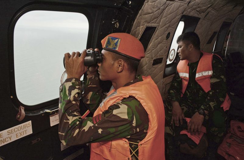 © Reuters. Membros da Força Aérea da Indonésia observam o oceano em busca de corpos das vítimas do voo da AirAsia caído no Mar de Java