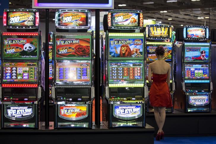 © Reuters. Visitor tries a slot machine during the Global Gaming Expo Asia in Macau