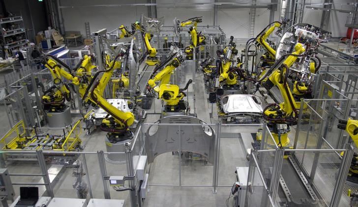 © Reuters. Robot arms work at the body of a Porsche Macan at the new plant in the eastern German city of Leipzig