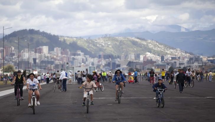 © Reuters. Equatorianos andam de bicicleta em aeroporto de Quito