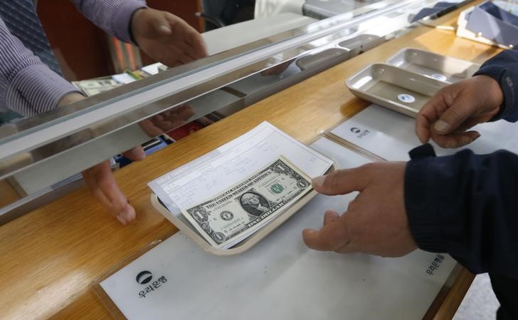 © Reuters. A South Korean businessman exchanges Korean won into the U.S. dollar at a bank branch in Paju