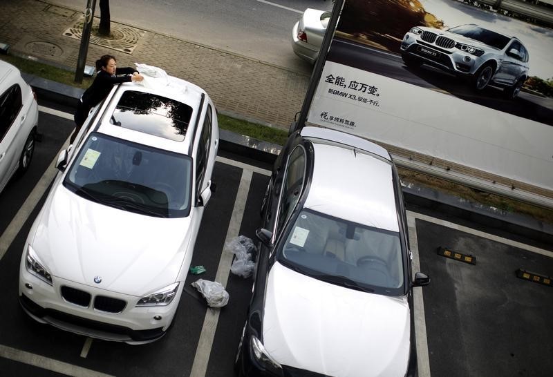 © Reuters. An employee removes a plastic cover from a new BMW car at a BMW dealership from the Baoxin Auto Group in Shanghai