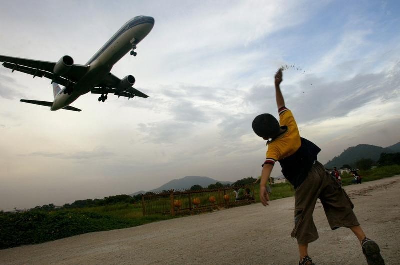 © Reuters. BOY WATCHES PLANE LAND AT GUANGZHOU'S BAIYUN AIRPORT.