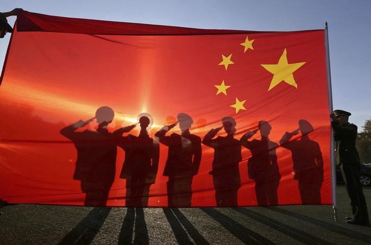 © Reuters. Policiais paramilitares aposentados saúdam a bandeira chinesa na Praça da Paz Celestial em Pequim