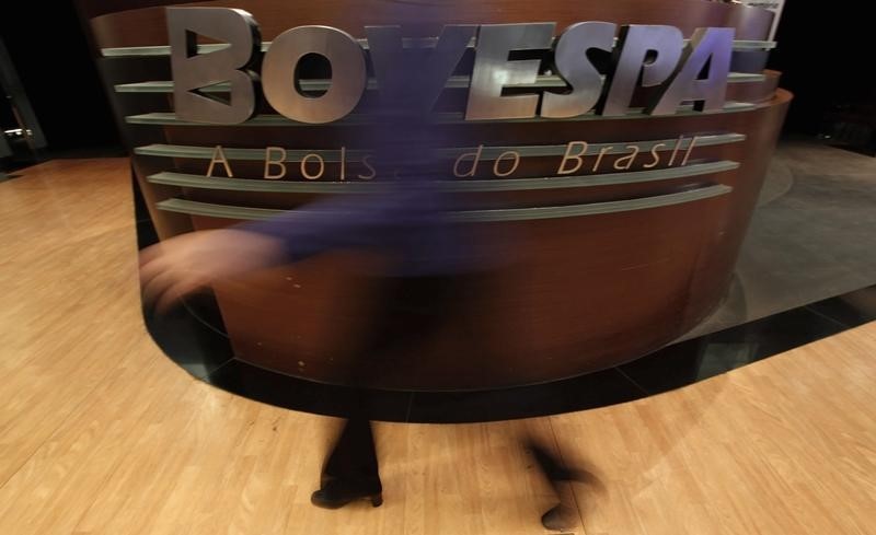 © Reuters. Mulher passa em frente a logotipo da Bovespa.