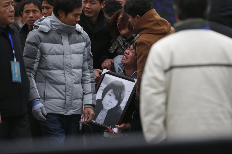 © Reuters. Relatives cry as they hold a picture of a victim at a memorial ceremony for people who were killed in a stampede incident last Wednesday during a New Year's celebration on the Bund, in Shanghai